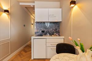 a kitchen with white cabinets and a table at Midtown Hotel Twin Studio in Amsterdam