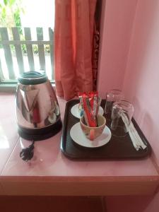 a tray with a tea pot and a plate with chopsticks at Wansawang Homestay in Pran Buri