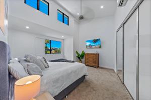 Un dormitorio con una cama grande y ventanas. en Airlie Nights, en Airlie Beach 26 fotos más