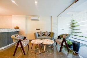 sala de estar con 2 sillas y mesa en FabHotel Soft Petals, en Gurgaon