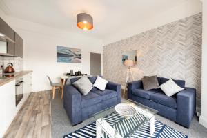 a living room with two blue couches and a table at Stunning 5-Bed Maisonette in Bristol in Bristol