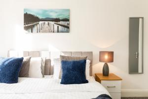 a bedroom with a white bed with blue pillows at Stunning 5-Bed Maisonette in Bristol in Bristol