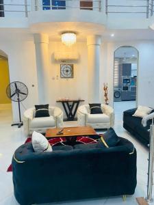 ein Wohnzimmer mit einem Sofa und einem Tisch in der Unterkunft Nanani Villa - Harmonious Paradise in Kumasi