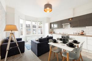 布里斯托的住宿－Stunning 5-Bed Maisonette in Bristol，厨房以及带桌椅的起居室。