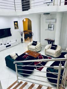 sala de estar con 1 cama y 2 sillas en Nanani Villa - Harmonious Paradise en Kumasi