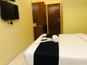 Una habitación de hotel con una cama con una toalla. en 7even Hills- International Airport By Glitz Hotels en Bombay