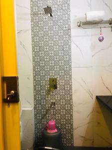 a bathroom with a shower with a pink pot at 7even Hills- International Airport By Glitz Hotels in Mumbai