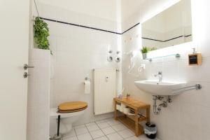 une salle de bain blanche avec un lavabo et des toilettes dans l'établissement FullHouse - Halle - Paulus Apartment - Nespresso, à Halle-sur-Saale