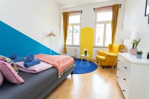 une chambre avec un lit et une chaise jaune dans l'établissement FullHouse - Halle - Paulus Apartment - Nespresso, à Halle-sur-Saale