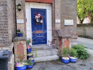 a blue door on a house with potted plants at The Old Rectory in Dorchester