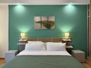 een slaapkamer met een groot bed met een blauwe muur bij 1 BedRoom Apt - Live Like A Local In Kolonaki in Athene