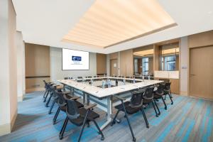 uma grande sala de conferências com uma mesa longa e cadeiras em Holiday Inn Express Changchun Ecological Square, an IHG Hotel em Changchun