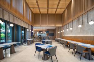 a restaurant with tables and chairs and a bar at Holiday Inn Express Changchun Ecological Square, an IHG Hotel in Changchun
