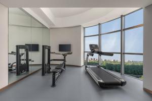 an empty gym with a treadmill and a desk at Holiday Inn Express Changchun Ecological Square, an IHG Hotel in Changchun