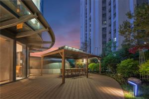 une terrasse avec une table et des chaises dans un bâtiment dans l'établissement Holiday Inn Express Changchun Ecological Square, an IHG Hotel, à Changchun