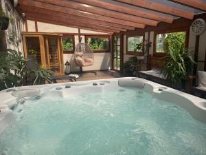 duży jacuzzi w pokoju z oknami w obiekcie Platán Apartmanház w mieście Balatongyörök