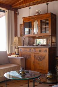a living room with a large wooden cabinet at CALDERA close to the port, airport & Athens in Rafina