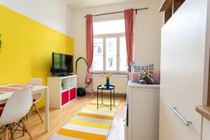 ein Wohnzimmer mit einem Tisch und einer gelben Wand in der Unterkunft FULL HOUSE STUDIOS - Paulus Apartment - Nespresso inklusive in Halle an der Saale