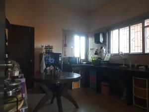 a kitchen with a table in the middle of a room at Meghamala Bed and Breakfast in Kolthare