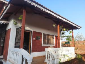 a small house with a white fence in front of it at Meghamala Bed and Breakfast in Kolthare +6 photos