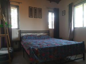 a bedroom with a bed with a quilt on it at Meghamala Bed and Breakfast in Kolthare