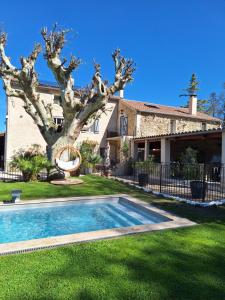 a house with a tree and a swimming pool at Le gite de Fa nny Moulin de Tartay en Avignon in Avignon