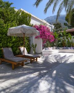 a patio with two chairs and an umbrella at Kassandra Boutique Hotel in Oludeniz