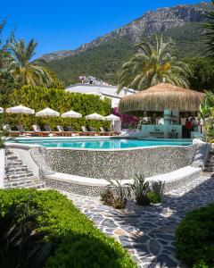 a swimming pool with chairs and umbrellas in a resort at Kassandra Boutique Hotel in Oludeniz