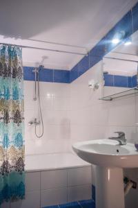 a bathroom with a sink and a shower and a tub at DOMES APARTMENTS in Kallithea Halkidikis +60 photos