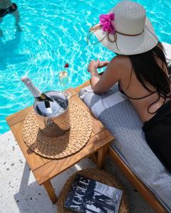 a woman in a hat sitting at a table next to a pool at Kassandra Boutique Hotel in Oludeniz