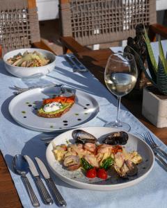 a table with plates of food and a glass of wine at Kassandra Boutique Hotel in Oludeniz