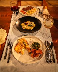 a table with two plates of food and glasses of wine at Kassandra Boutique Hotel in Oludeniz
