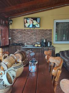 eine Küche mit einem Holztisch und einem TV an der Wand in der Unterkunft Casa Dana in Haţeg