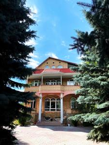 una casa con techo rojo y dos árboles en Private Luxury Villa - Issyk Kul en Cholpon-Ata