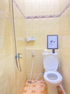 a bathroom with a shower and a toilet in it at Good Feeling Hostel in Banyuwangi