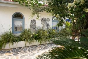a house with two windows and plants in front of it at Kassandra Boutique Hotel in Oludeniz
