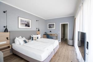ein Schlafzimmer mit einem großen weißen Bett und einem TV in der Unterkunft Hotel Wehrburg in Cuxhaven