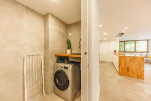a laundry room with a washer and dryer at Bravissimo Turbau Entresol A, with 3 bedrooms in Girona