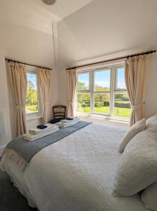 a bedroom with a large bed with two windows at Humphries Cross Apartments in Rye