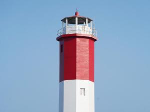 a red and white lighthouse against a blue sky at Gaomei Lighthouse in Taichung