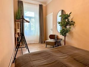 ein Schlafzimmer mit einem Bett, einem Spiegel und einem Stuhl in der Unterkunft Wurmbstraße in Wien