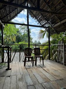 - deux chaises assises sur une terrasse en bois avec vue dans l'établissement Mystay, à Mawanella