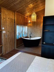 ein Bad mit einer Badewanne in einem Zimmer in der Unterkunft Retro House Mộc Châu in Mộc Châu