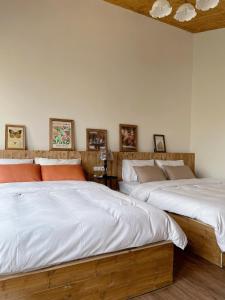dos camas sentadas una al lado de la otra en un dormitorio en Retro House Mộc Châu, en Mộc Châu
