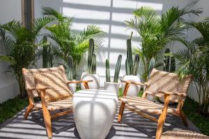 2 Stühle und eine Vase auf einer Terrasse mit Pflanzen in der Unterkunft Umalas Jungle Amazing View-3BDR-Canggu-Huge pool-PS5 in Kerobokan