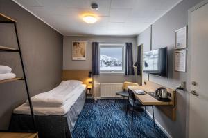 ein Hotelzimmer mit einem Bett und einem Schreibtisch in der Unterkunft HOTEL SØMA Aasiaat in Aasiaat
