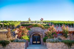 een toegang tot een wijnmakerij met bloemen en wijnranken bij The Meritage Resort and Spa in Napa