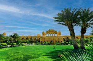 ジャイサルメールにあるFort Rajwada,Jaisalmerの公園内のヤシの木がある大きな建物