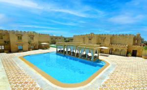 a large swimming pool in front of a castle at Fort Rajwada,Jaisalmer in Jaisalmer