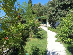 een pad door een tuin met bomen en struiken bij Leonica in Omiš